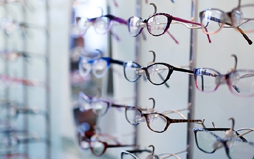 Brillengestell-Auswahl im Optikerladen, verschiedene Brillen im Regal